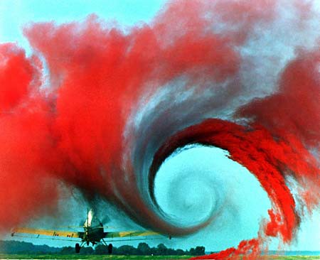 Red smoke is used to show a vortex of air created behind the wing of an airplane