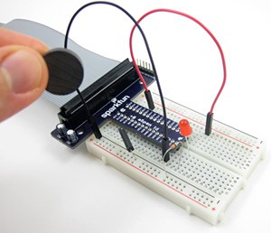 A magnet sensing circuit on a breadboard is off when a magnet is held away
