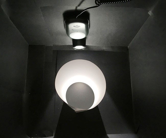 Top view of the opened-up test box. The cylinder stands centered in front of the flashlight.