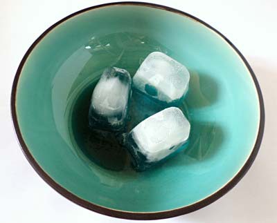 Three similarly sized ice cubes placed in a bowl and arranged to make a triangle