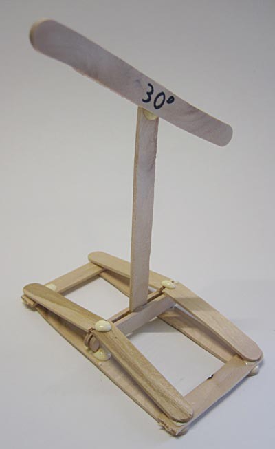 A popsicle stick at a thirty degree angle glued to a support structure made of popsicle sticks