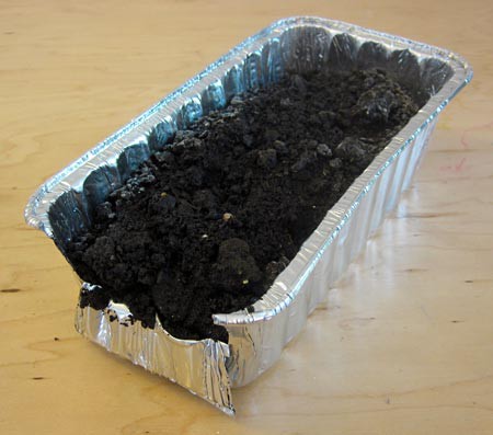 The short side of an aluminum bread pan is cut and folded over