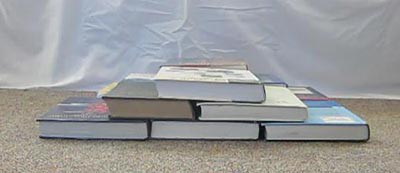 Six textbooks are laid flat and arranged into a pyramid