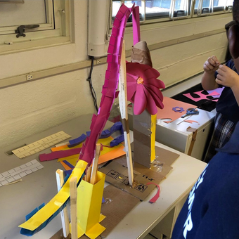 Paper roller coaster built by students from success story about teacher who did engineering design and computer science projects with middle school students