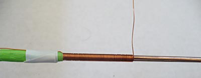 Copper wire is wrapped neatly around a nail sized iron core