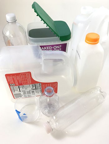 Three plastic bottles, a plastic jug, a graduated cylinder and two plastic containers