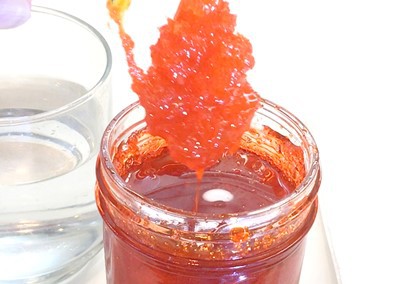 Rock candy being pulled up from a jar with thick syrup.  