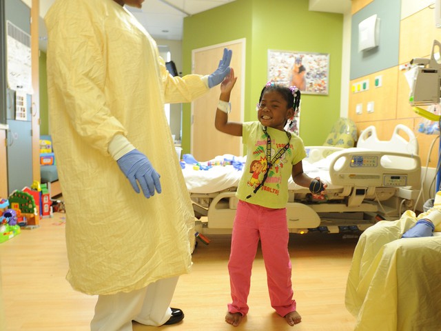 Practitioner in hospital high-fiving girl lpatient 