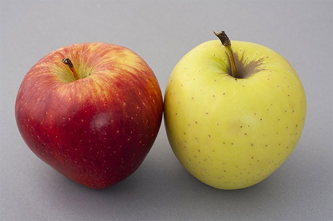 A green apple and a red apple sitting side-by-side.