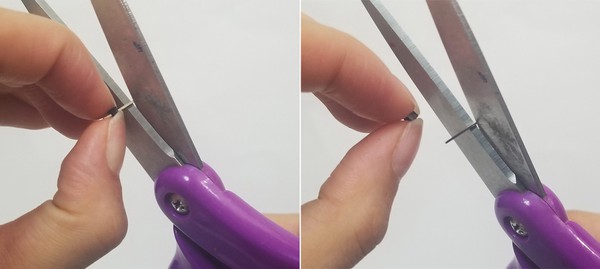 Fingers pinching black plastic piece of male header pins while scissors are pinching metal wire. Fingers pinching black plastic piece of male header pins while scissors have removed metal wire