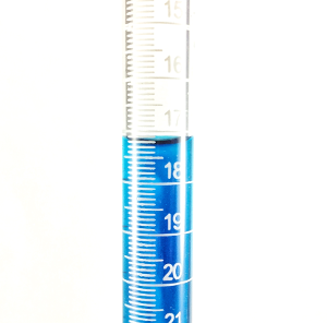 A buret is filled with blue liquid and the meniscus is used to measure the fluid level