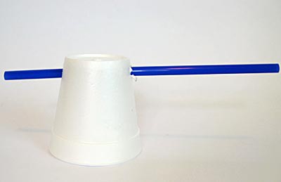 A straw is inserted through the base walls of a styrofoam cup