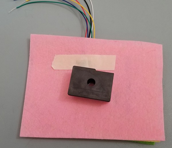 Dust sensor patch with wires threaded through. 