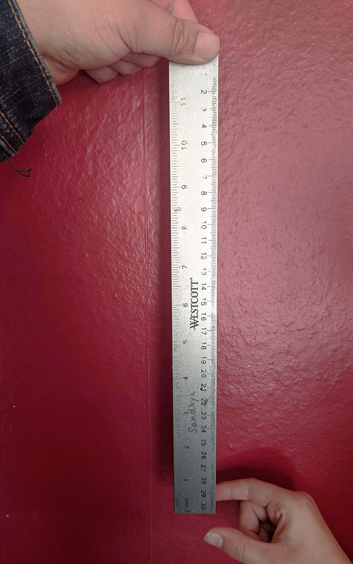Hand ready to grab a ruler being dropped to test reaction time
