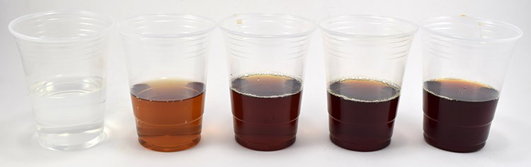 Five cups filled with different concentrations of tea