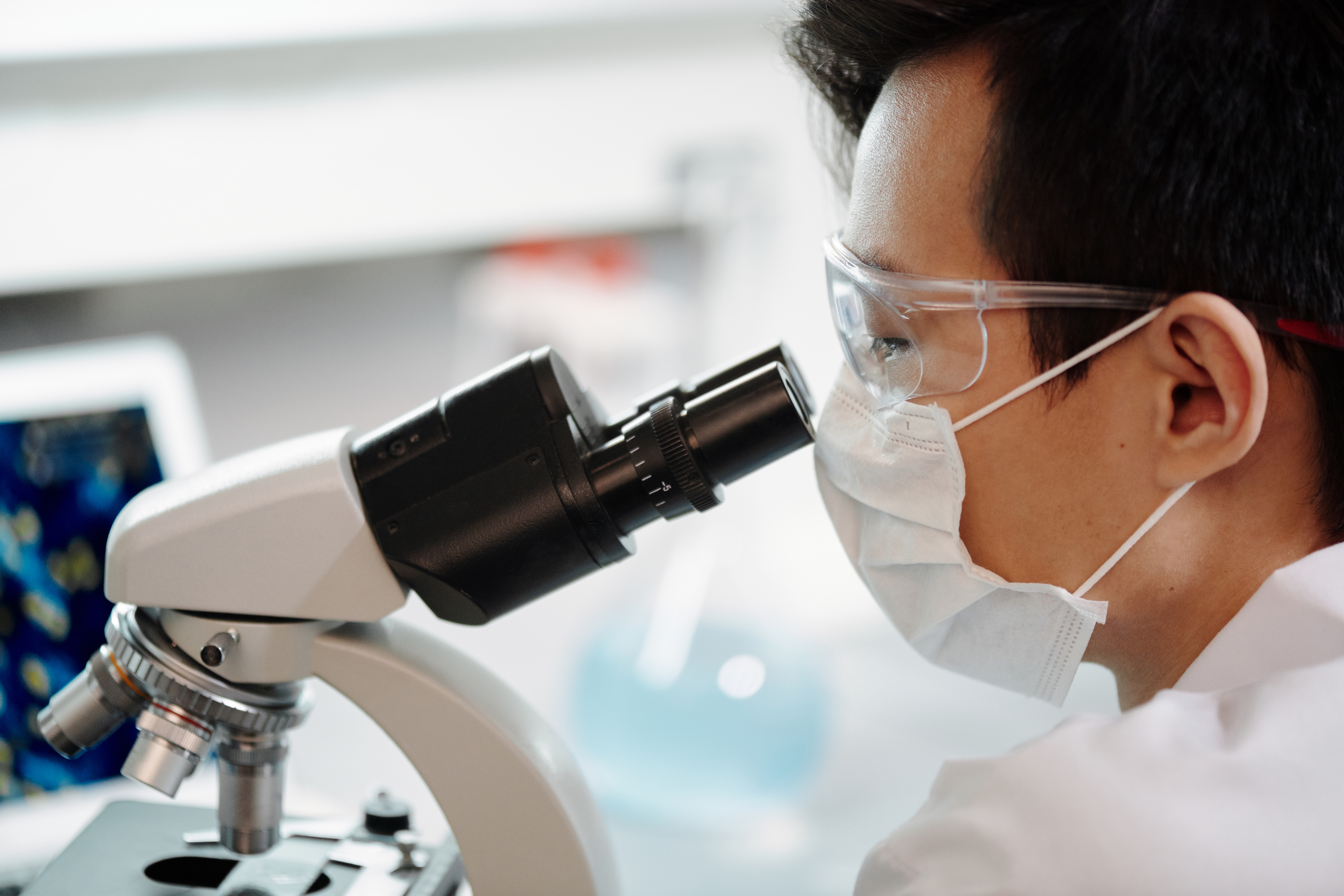 female cytogenetic technician looking through microscope