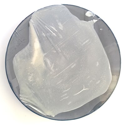 Plate with plastic wrap and a slightly translucent sheet sticking to it.