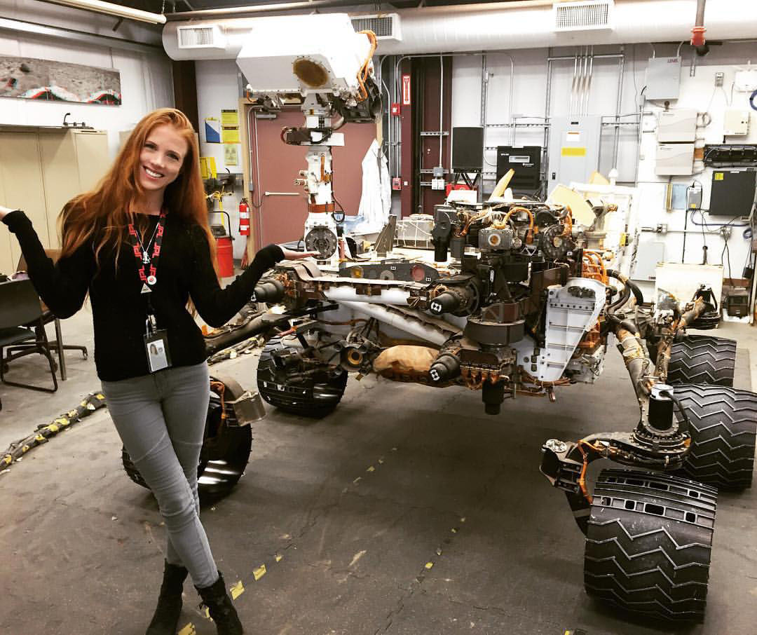 female robotics engineer adjusting robot