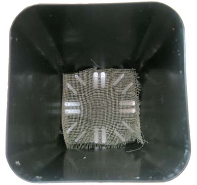 Photograph of a square of cheesecloth in the bottom of a pot.