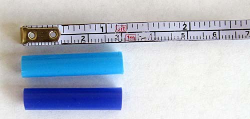 Two 3 cm-long straw pieces next to a tape measure