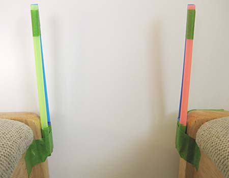 Bridge towers taped to chairs and positioned apart from each other.