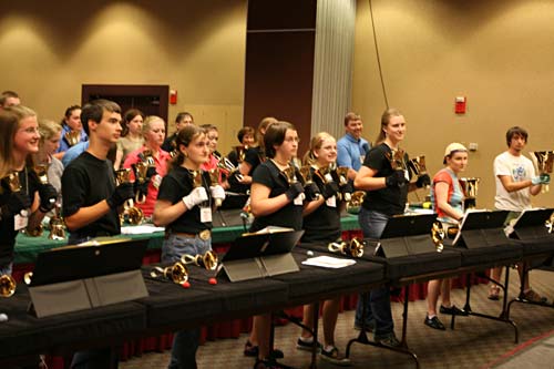 A room full of people practice playing the handbell