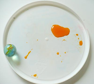 Marble trajectories are created by first rolling them in food coloring as shown in this picture.
