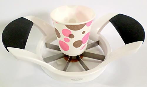 A cup placed on an apple cutter, placed on a maple candy.