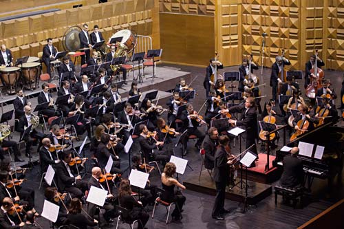 Orchestra of mostly string instruments.