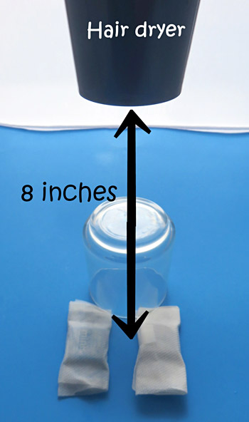 An air dryer held at 8 inches above the candy blows hot air on the candies.