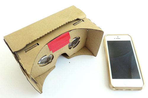 Google cardboard virtual reality headset next to a smartphone