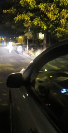 Photo of a cars headlights shining on a person at night