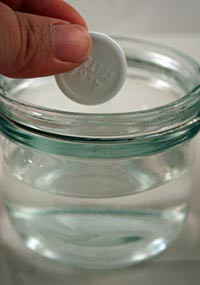 Alka-Seltzer tablet being placed in a glass of water