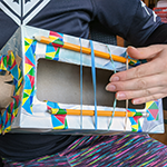 Simple guitar made from a cardboard box and rubber bands and decorated