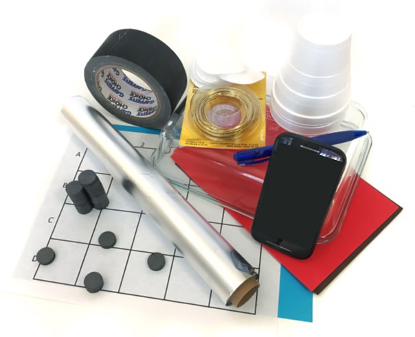 Tape, aluminum foil, a stack of disc magnets, grid paper, construction paper, a pen, styrofoam cups and a glass dish