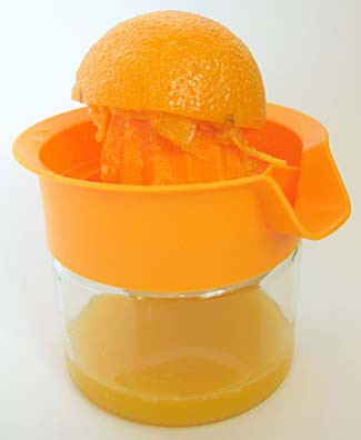 A plastic juicer is used to juice half of an orange over a cup