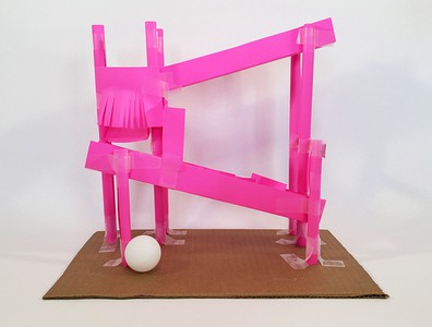 A switchback ball run with several obstacles built from paper and tape