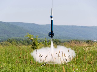 model rocket launching in a field