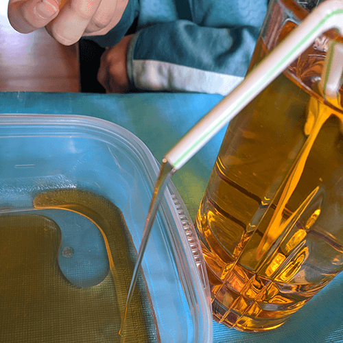 Water flowing from a siphon made out of straws between two containers