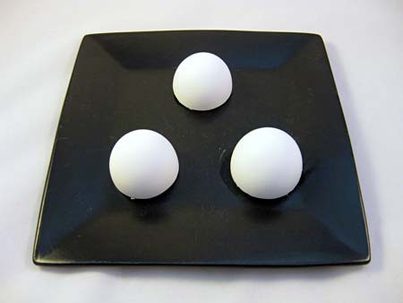 Three halved eggshells are placed in a triangle on a plate