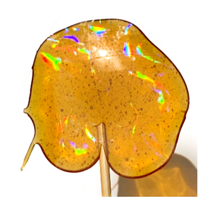 Homemade lollipop candy with a rainbow pattern that shows in the light - Unicorn-themed Make-Believe STEM Science Experiments