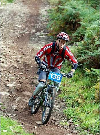 A bike rider going down dirt path