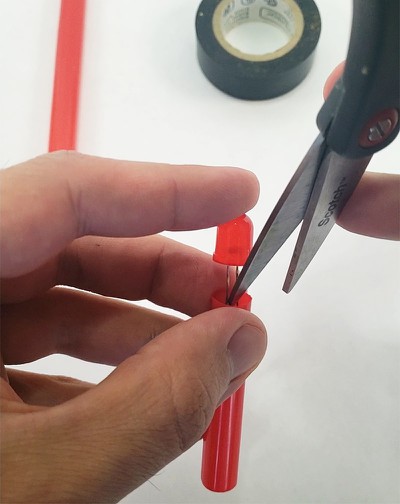  LED and battery being pressed into straw