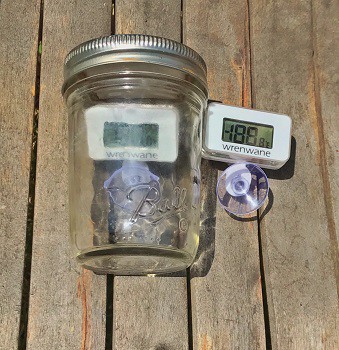 Two thermometers: one inside a jar, and the other next to the jar