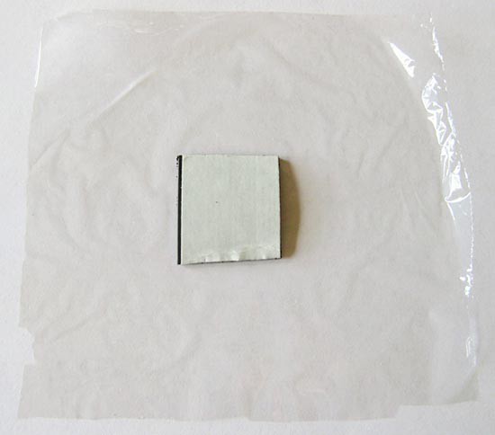 Square of magnetic tape placed on a larger square of plastic wrap