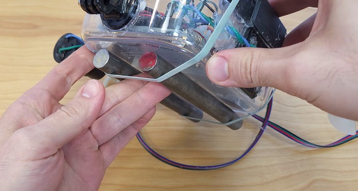 Two steel rods attached to the underside of the plastic ROV container with rubber bands 