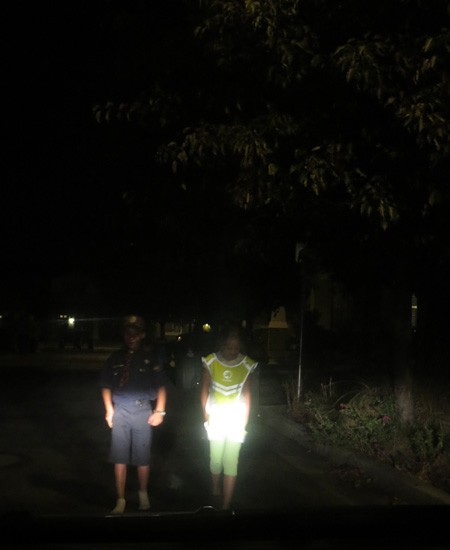 two pedestrians in the dark wearing bright safety gear
