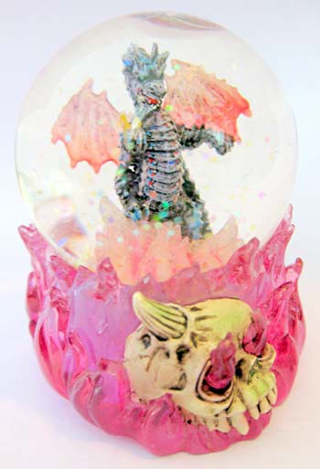 Glitter floats around a dragon figurine in a snow globe