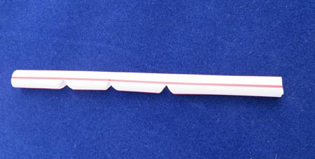 Three notches are cut into the side of a plastic straw