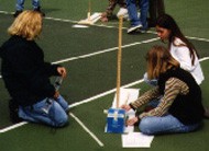 Students measure the length of a vertically held meter sticks shadow